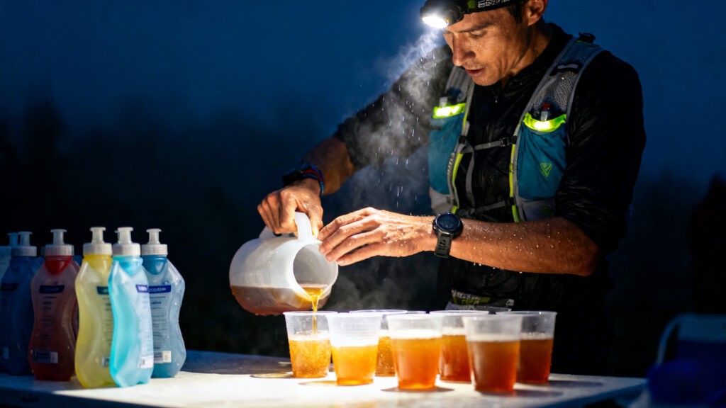 Coureur remplissant des flasques avec boisson aux électrolytes